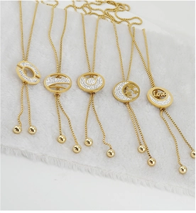 Detail of adjustable 18K gold plated sweater necklaces with CZ pendants on white plush