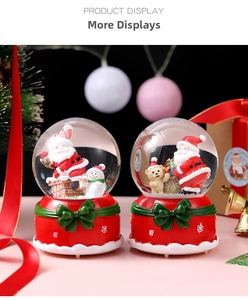 Detailed view of two Christmas crystal balls with Santa and snowman on red bases