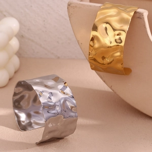 Detail of wide open cuff bracelet with hammered water ripple texture in gold and silver