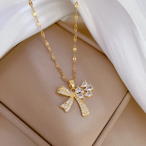 Luxury gold butterfly pendant necklace with zircon crystals on white silk background