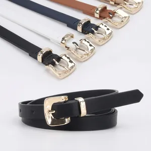 Detail of slim black synthetic leather belt for women with textured gold metal buckle