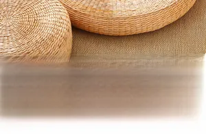Dettaglio del cuscino in paglia naturale intrecciata con trama spessa e bordi rotondi
