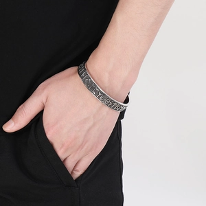 Vintage Viking compass bangle with Norse runes on a man's wrist, antique silver finish