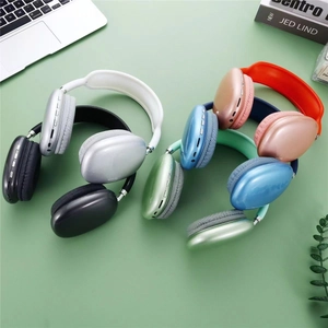 Overhead view of multi-color wireless over-ear headphones on a desk with a laptop
