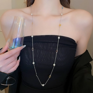 Model wearing a multilayer necklace with white pearls and colorful square crystal beads