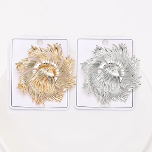 Détail de broches créatives en métal en forme de fleur dorées et argentées sur cartes