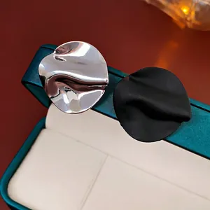 Asymmetric wavy metal stud earrings in silver mirror and matte black finishes