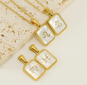 Détail de colliers signes du zodiaque plaqués or 18 carats avec nacre et motifs ajourés