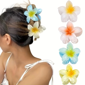 Detailed view of colorful plumeria flower hair claws for beach vacation hairstyles