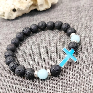 Handmade volcanic stone bead bracelet featuring a blue cross pendant and silver spacers