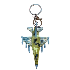 Miniature fighter jet model keychain with metal texture and camouflage paint on white background
