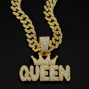 Macro shot of gold-plated alloy Cuban chain with rhinestone encrusted QUEEN crown pendant