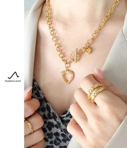 Detail of 18k gold plated stainless steel heart necklace and rings set on model