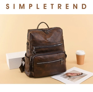 Detail of dark brown faux leather backpack with multiple zipper pockets and top handle