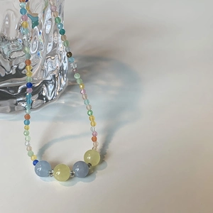 Macro shot of summer rainbow beaded necklace with colorful cat-eye stones and seed beads