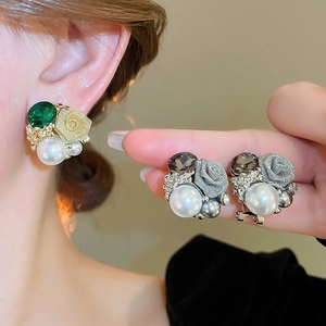 Détail de boucles d'oreilles rose et perle avec pétales en tissu et pierre taillée