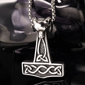 Gros plan détaillé du pendentif marteau de Thor argenté avec relief de tête de bélier
