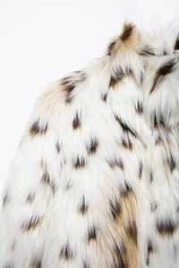 Detail shot of fluffy faux leopard fur texture with soft white and brown spotted plush