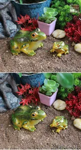 Detail of two resin frog figurines in a miniature succulent garden with red maple leaves