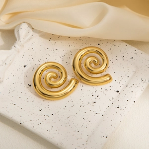 Macro shot of gold spiral stud earrings featuring a high-polish metallic textured finish
