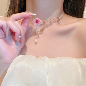 Elegant floral pearl tassel necklace with pink crystal flowers on a fashion model
