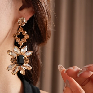 Gros plan de boucles d'oreilles vintage fleurs avec cristaux ambrés et détails géométriques