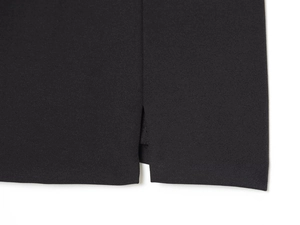 Primer plano de la abertura lateral y textura del tejido en vestido corto negro