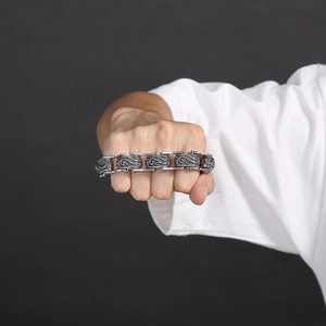 Macro detail of men's vintage steel bracelet with floral relief pattern on wrist