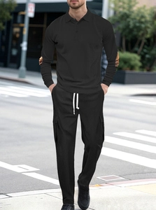 Detail of men's black ribbed knit set with polo shirt and cargo pants in urban setting