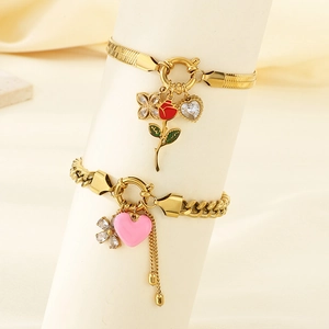 Detail of golden stainless steel heart and flower pendants on a jewelry display stand