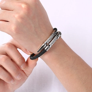 Close-up of punk style stainless steel nail head bracelet with woven strap.