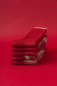 Détail de cinq paires de chaussettes en laine rouge avec motifs de flocons nordiques