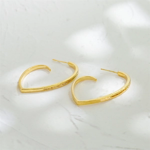 Elegant 14K gold heart-shaped earrings displayed on a luxury white marble surface