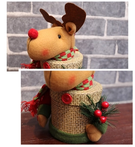 Close-up of reindeer Christmas candy jar details with plaid scarf and faux pine needle decor