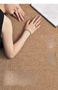 Close-up of sisal-style woven rug texture with a person reading, showcasing eco-friendly fibers