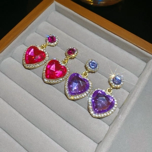 Gros plan de boucles d'oreilles cœur en cristal avec micro-strass dans un écrin