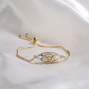 Detailed macro view of a gold-plated adjustable bracelet with sparkling marquise zircons