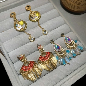 Detailed macro shot of three vintage fan tassel earrings displayed in a luxury velvet jewelry box