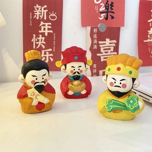 Macro detail of hand-painted wooden god figurines with gold ingots for desk decor