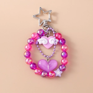 Detailed view of pink and purple beaded keychain with winged heart and star pendants