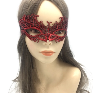 Detail of red lace masquerade mask showing intricate hollow embroidery and texture