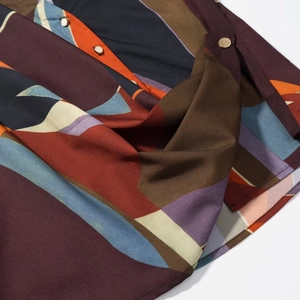 Detail of abstract geometric print on soft long sleeve shirt with gold button accents