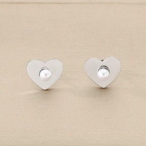 Gros plan de boucles d'oreilles perles en forme de cœur avec métal argenté ajouré