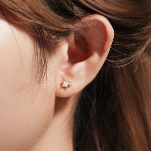 Close-up of gold stud earring featuring two square stacked gemstones on a model's ear