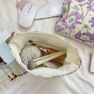 Top view of floral canvas makeup bag showing interior storage for cosmetics and brushes