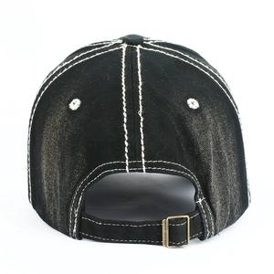 Detail of black washed cotton baseball cap with white contrast stitching and metal buckle