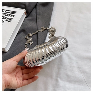 Close-up of metallic silver snail-shaped bag with detailed vertical stripe texture