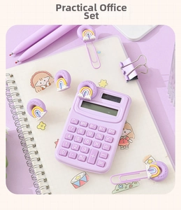 Close-up of a purple stationery set with a mini calculator, pens, and rainbow clips