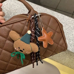 Dettaglio di corda intrecciata, stella e orsetto di peluche su borsa a mano marrone
