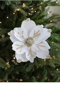 Detail of 24cm white magnolia Christmas flower with gold glitter on a lighted tree